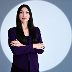 Portrait of a pretty brunette girl with long hair manager in a dark business suit in a circle of...