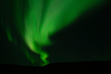 Winter scenic landscape night view of  Aurora Borealis/Northern lights dancing on the clear sky full of stars above lake Myvatn, north Iceland Beautiful winter wonderland/fairytale background scene. 