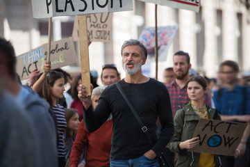 Obraz premium People with placards and protective suit on global strike for climate change.