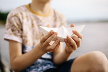 boy holds paper boat