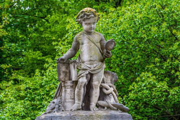 The sculpture of a boy looking at a mirror on the wall of Royal Palace in Brussels