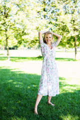 Naklejka premium Attraktive älterte Frau im Sommerkleid im Park