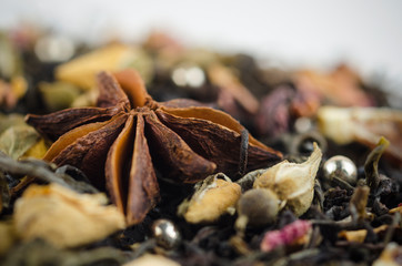 Closeup of anise star against the background of black tea with yellow rose