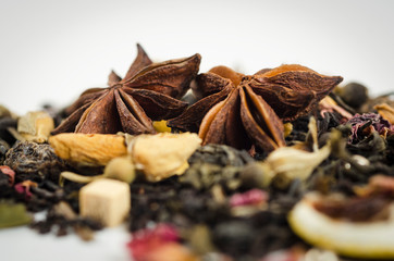 Anise stars on a background of black tea with a yellow rose