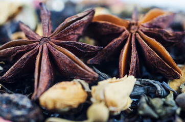 Anise stars against the background of black tea. Macro photography