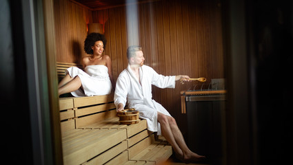Beautiful young couple sitting together in a sauna