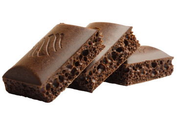 Three pieces of porous chocolate on a white background