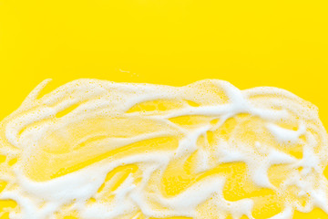 Washing concept. Foam frame on yellow top view copy space.