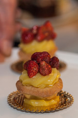 Close up of little cake with yellow cream and strawberry