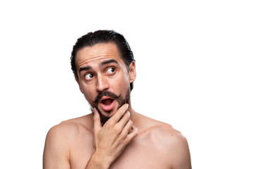 Fototapeta premium Thoughtful handsome bearded man with mustaches standning bare isolated over white background and looking at the right upper corner. Concept of morning treatment. Place for advertising