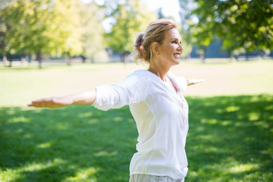 Attraktive ältere Frau macht Übungen im Park 