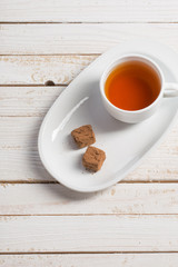cup of tea with chocolate candy on wooden table