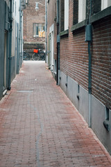 Fototapeta na wymiar vélo avec un panier rouge au fond d'une ruelle d'Amsterdam