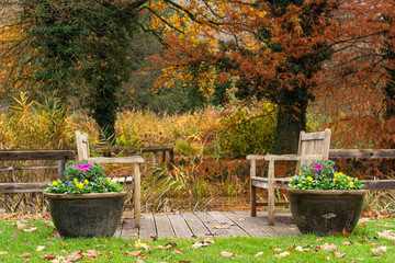 Sitting area with pair of benches at a pond.