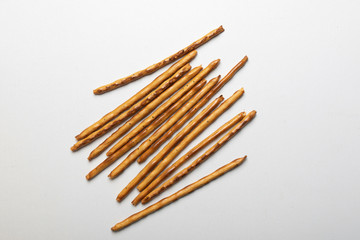 bread sticks scattered on a white background, crispy snack with poppy seeds