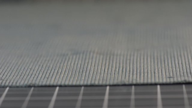 Women's hand cuts cloth with the rotary cutter, close up
