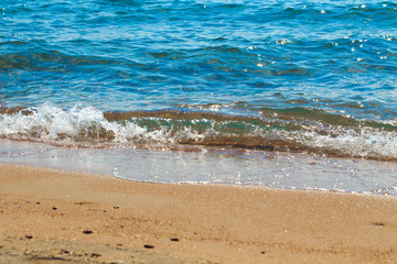 sandy beach and blue sea wave. Beautiful natural background. Tourism and travel.