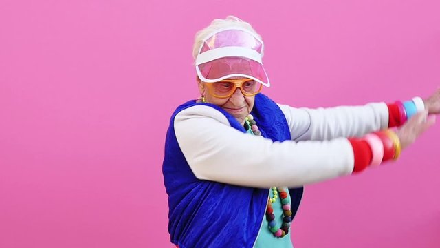 Funny grandmother portraits. 80s style outfit. Dab dance on colored backgrounds. Concept about seniority and old people