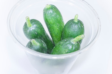 Little fresh cucumbers packaged for picnic in PET plastic cup