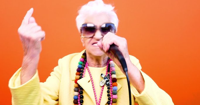 Funny grandmother portraits. Senior old woman dressing elegant for a special event. Rockstar granny on colored backgrounds