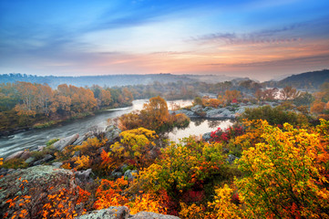 beautiful autumn landscape with colorful trees and foggy river on sunset