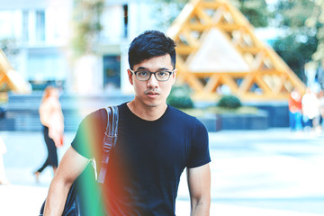 Young handsome asian men wearing casual plain shirt and backpack at day in Sai Gon city, Vietnam