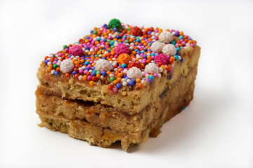 Peruvian classic dessert, turron de Doña pepa with honey and candies, isolated over a white background.