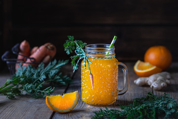 Healthy food. Carrots and carrot juice with orange ginger in a glass jar in a metal basket on a...