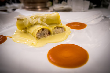 Homemade Italian Cannelloni with ricotta cheese, beef and bechamel sauce, Gourmet setting with pumpkin cream