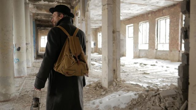 Traveler walks the ruins of a building in winter