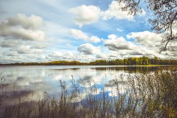 Reflection of blue sky and white clouds in the water of a small lake