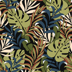 Abstract tropical seamless pattern with beautiful yellow and blue leaves and plants on a dark background.  Modern abstract design for fabric, paper, interior decor. Beautiful seamless vector 