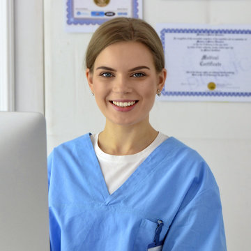 Beautiful smiling female doctor. Happy expert of a clinic. Pretty woman practitioner. Mature successful physician. Healthcare worker. Portrait of a nice cheerful medic. Medical career.
