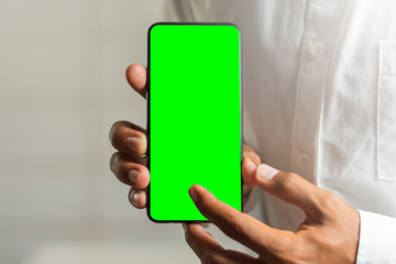businessman holding smartphone with green color on screen