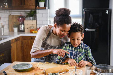 Mother and son baking together. American family. Single mother. Child helping mother.