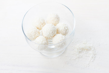 white round candies with coconut flakes in a glass vase 
