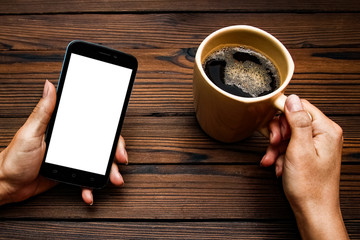 Female hands holding cup of coffee on wooden background