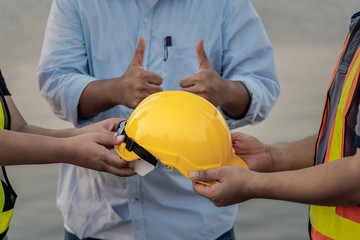 Techninians send to a helmet to an engineer friend, concept to pass on safety, with background of...
