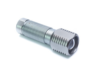 Metal flashlight over white background