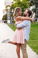 Fototapeta na wymiar Loving couple walking by street outdoors hugging