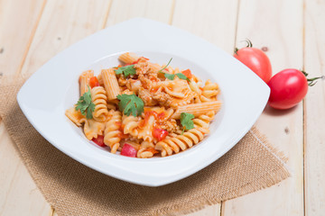 Spaghetti pasta with and tomato sauce on wood background