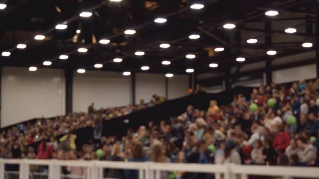 People are sitting in the stands. Strong blurred shot. Unrecognizable people.