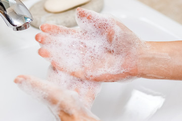 Hygiene concept. Washing hands with soap under the faucet with water