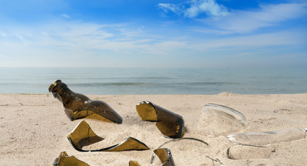 Fototapeta na wymiar Pollution from broken glass bottles lying on a beach