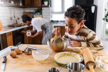 Son is helping mother to prepare pumpkin pie. American family. Single mother. Household chores for...