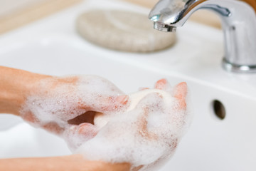 Hygiene concept. Washing hands with soap under the faucet with water