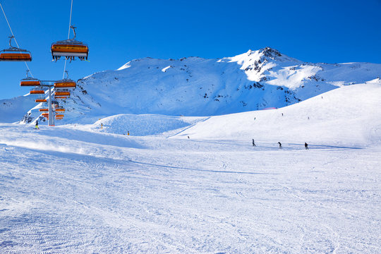 Ski lifts in the Alp mountains, Tirol, Austria. Bright blue sky and mountain covered with snow. 