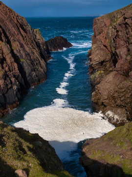 Sea spume or sea foam formed in West Ness Geo neral North Ham on the island of Muckle Roe in Shetland, UK.