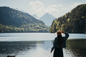 The girl in the dress and hat of the lake in the mountains