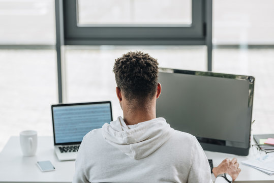 back view of african american programmer working on computers in office